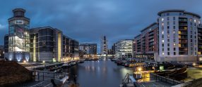 View of Leeds Dock, (Clarence Dock) at dusk with buildings lit up.